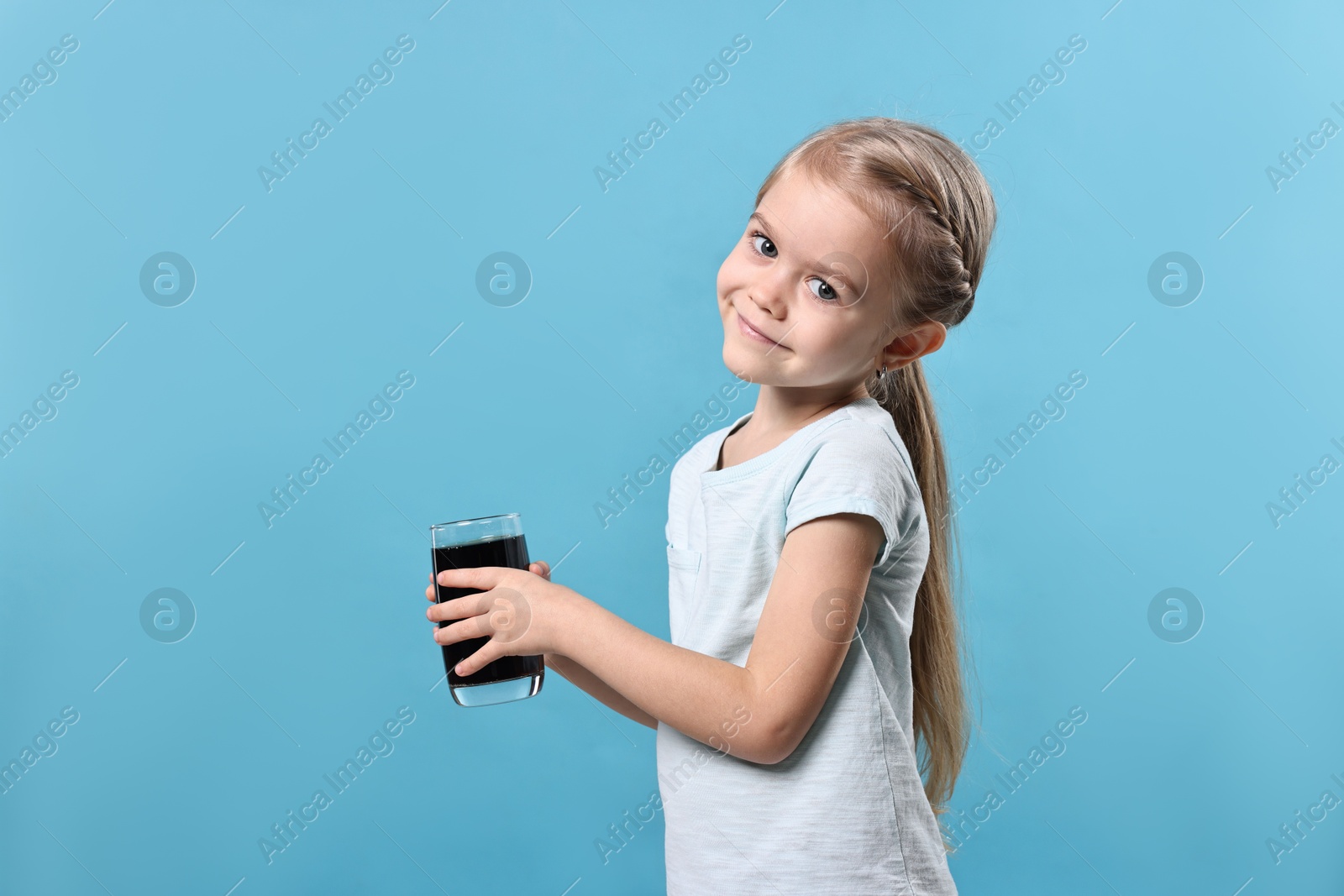 Photo of Girl with glass of refreshing soda drink on light blue background