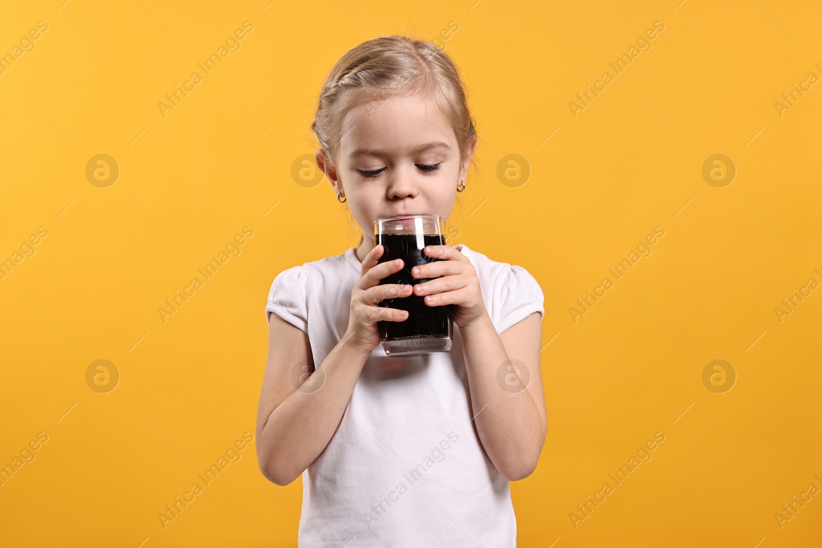 Photo of Girl with glass of refreshing soda drink on orange background