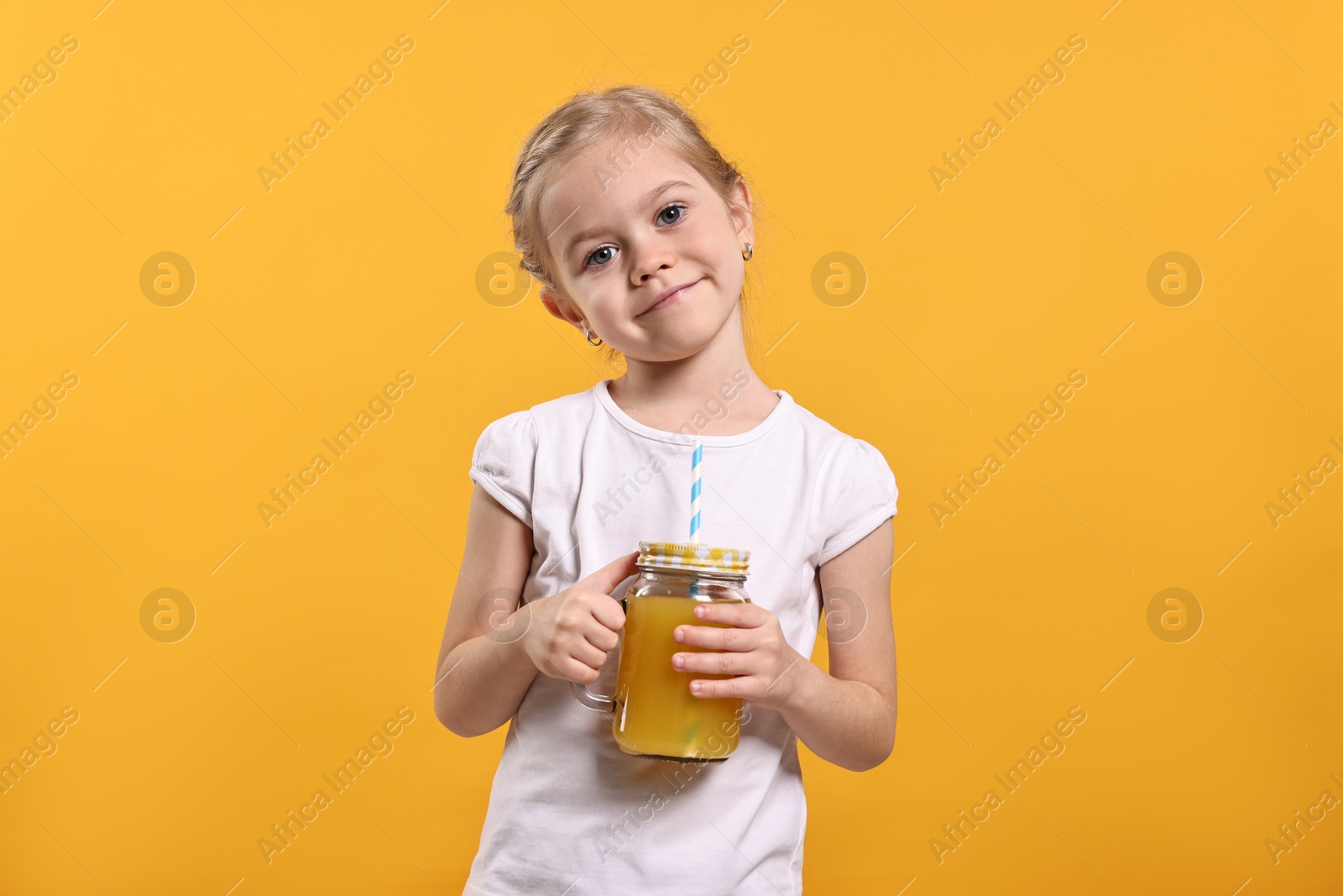 Photo of Girl with mason jar of juice on orange background. Refreshing drink