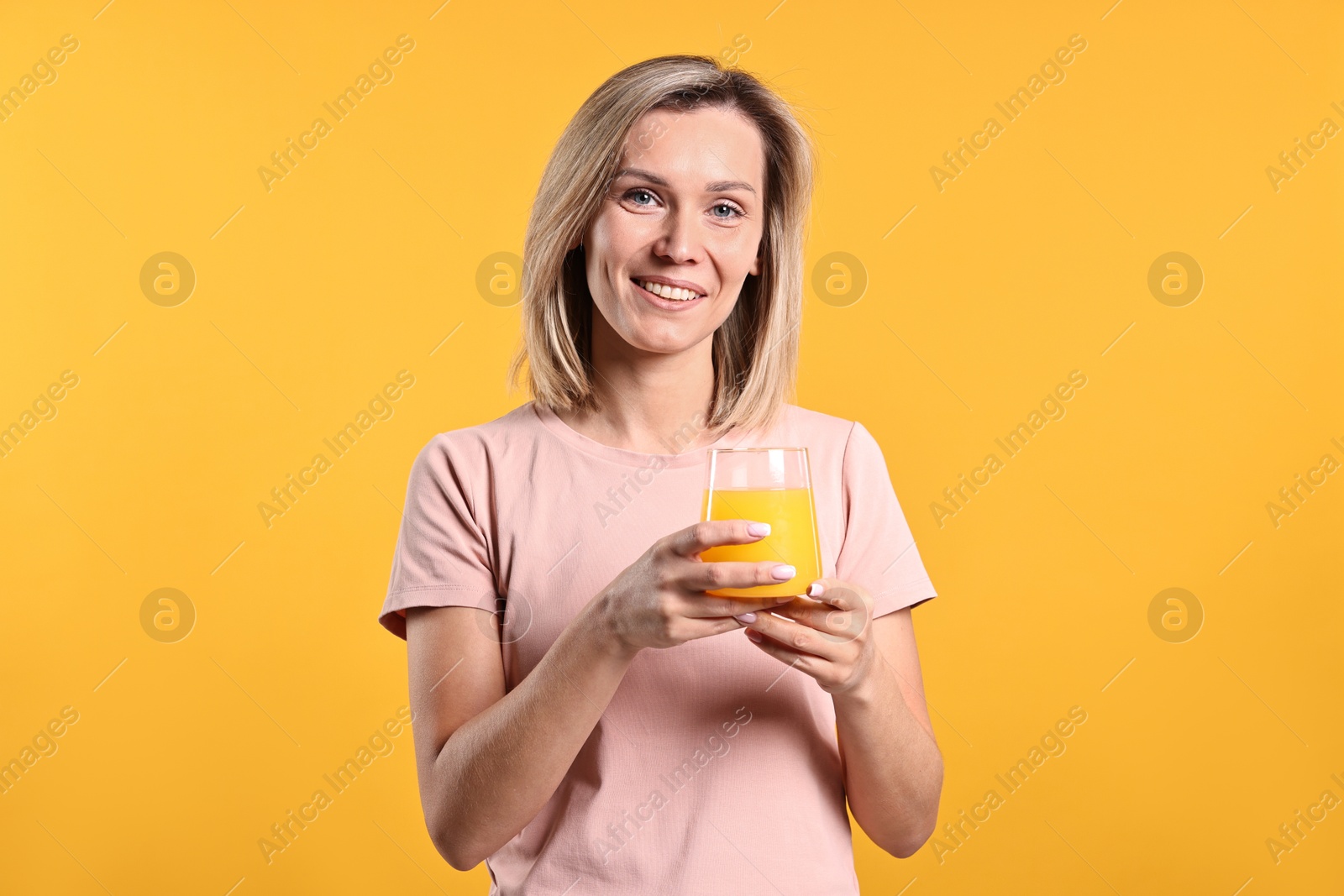 Photo of Woman with glass of juice on orange background. Refreshing drink