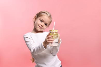 Photo of Girl with mason jar of lemonade on pink background. Refreshing drink