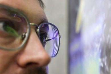 Photo of Man wearing stylish glasses on blurred background, closeup