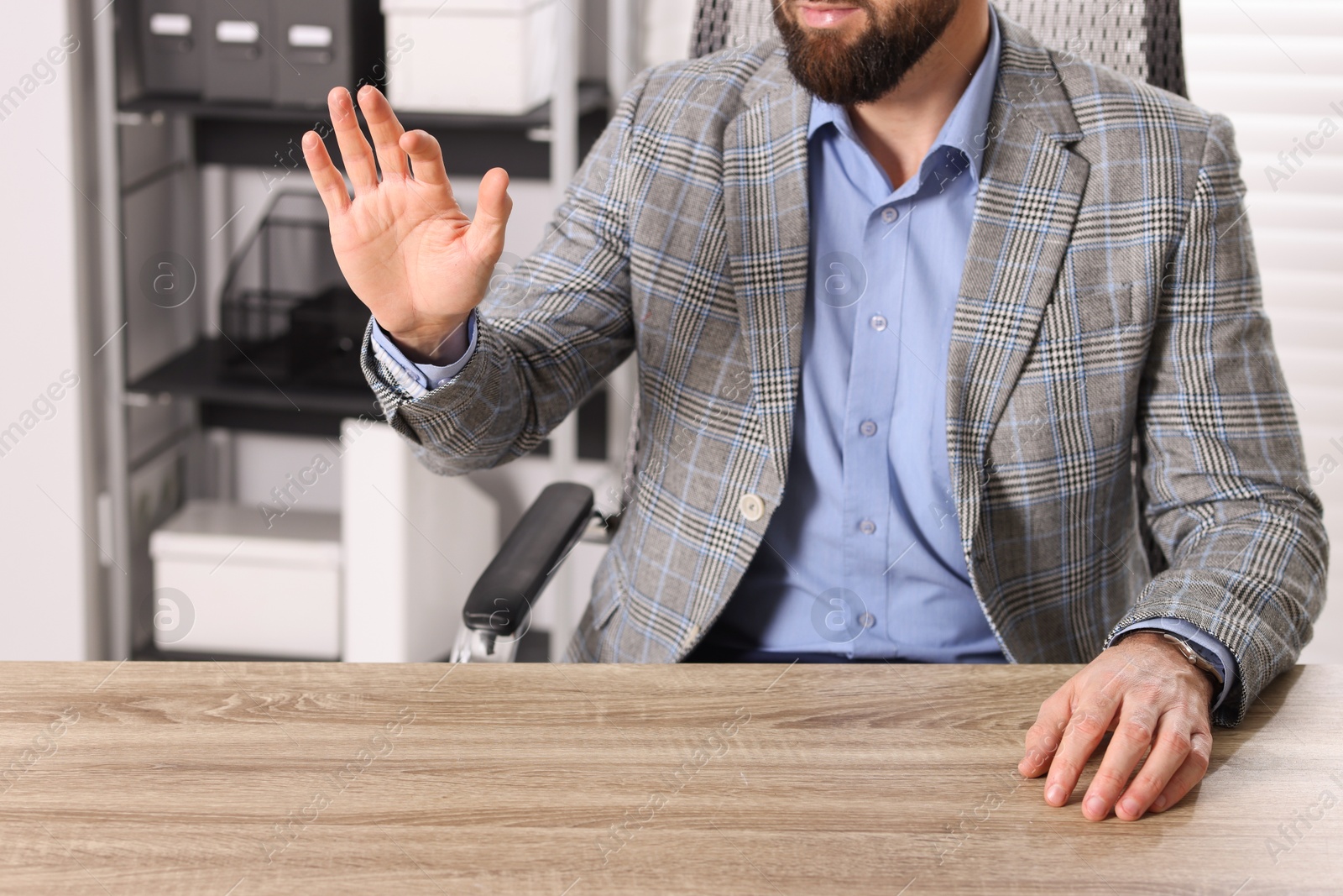 Photo of Man showing something at wooden desk in office, closeup