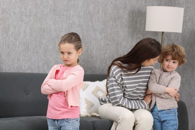 Photo of Resentful little kids and their mother arguing at home