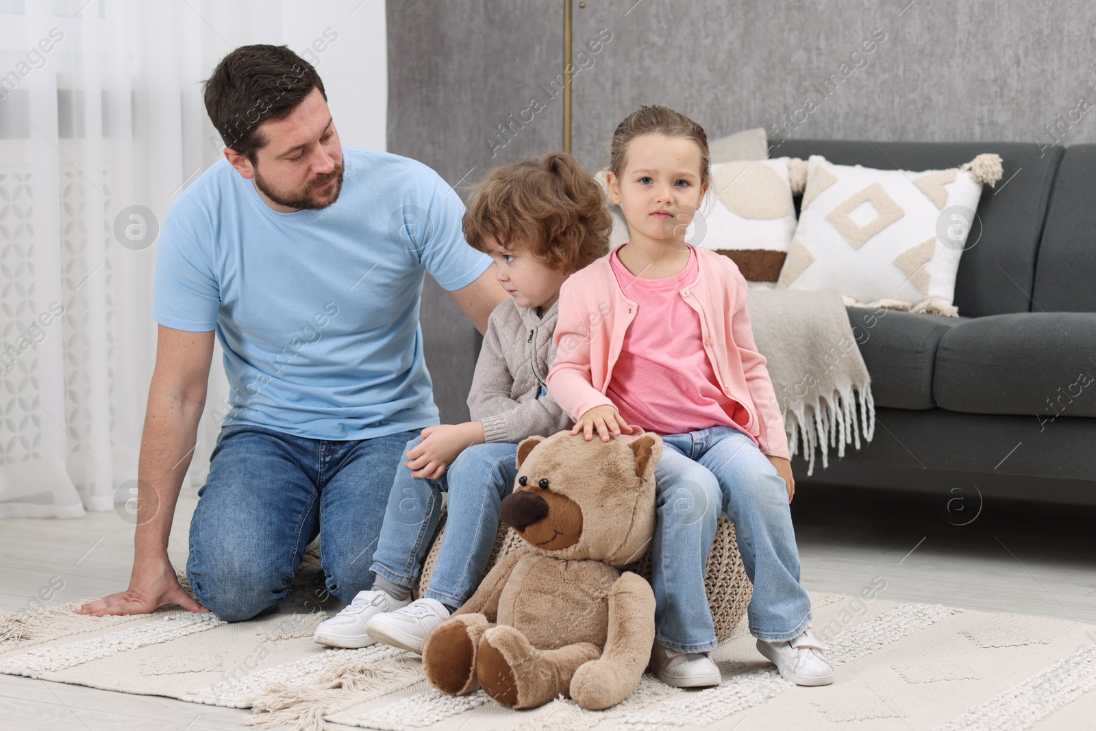 Photo of Resentful little kids and their father arguing at home