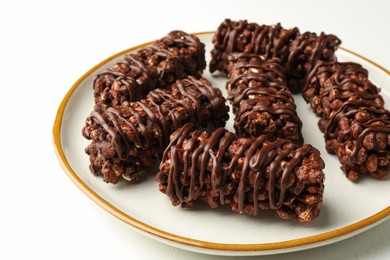 Photo of Delicious chocolate puffed rice bars on white table, closeup