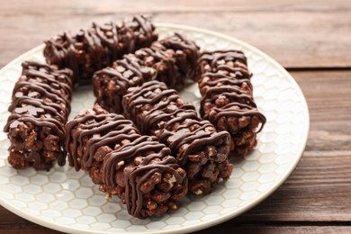 Delicious chocolate puffed rice bars on wooden table, closeup