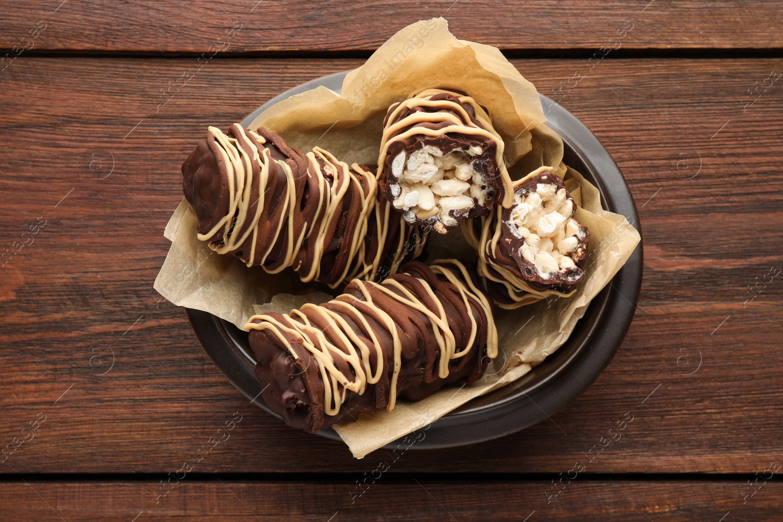 Photo of Delicious chocolate puffed rice bars on wooden table, top view