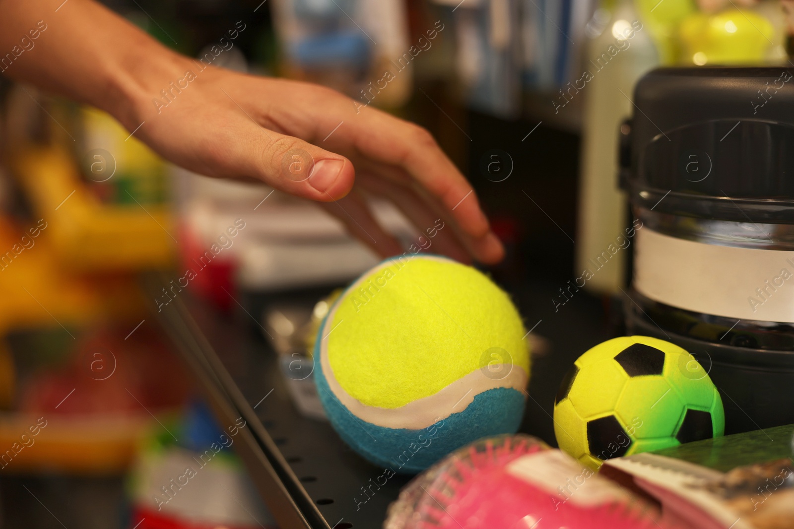 Photo of Woman choosing toy in pet shop, closeup