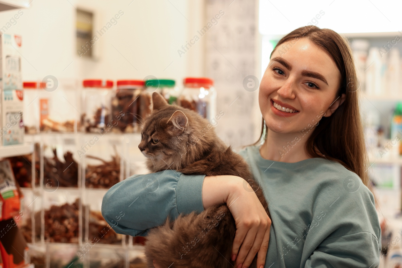 Photo of Woman with her cute cat in pet shop. Space for text