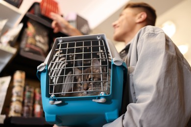 Photo of Man with his cute cat in pet shop, low angle view