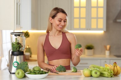 Photo of Weight loss. Happy woman with different ingredients for healthy shake at table in kitchen