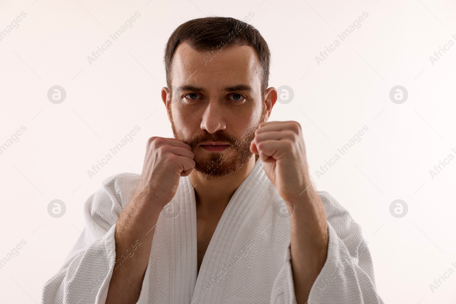 Photo of Karate fighter in uniform on white background