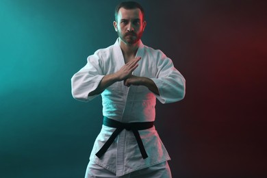 Photo of Karate fighter wearing uniform in color lights