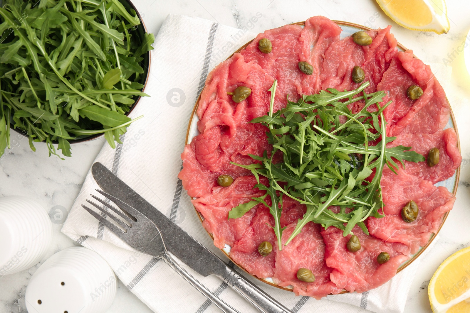 Delicious beef carpaccio served on white marble table, flat lay Photo of Delicious beef carpaccio served on white marble table, flat lay