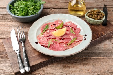 Delicious beef carpaccio served on wooden table