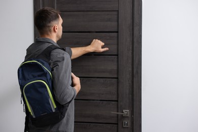 Photo of Man knocking on door to his friends apartment