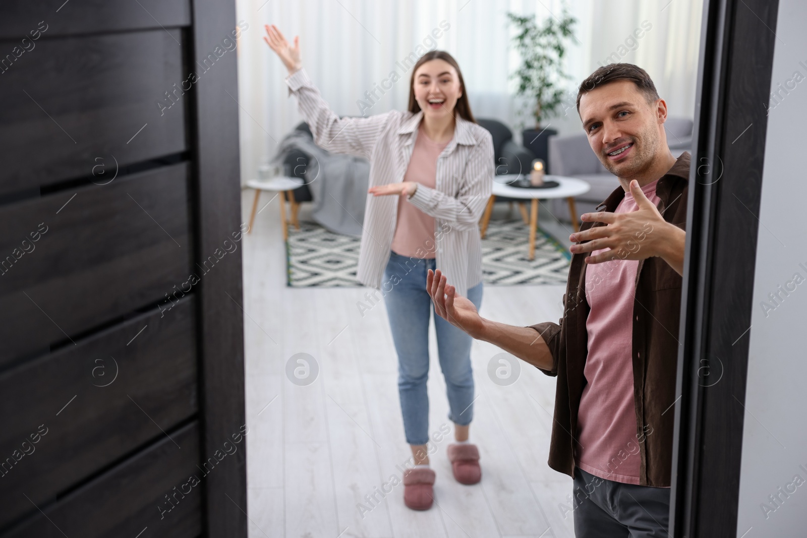 Photo of Lovely couple welcoming guests to their apartment