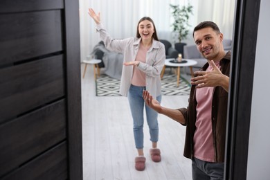 Photo of Lovely couple welcoming guests to their apartment