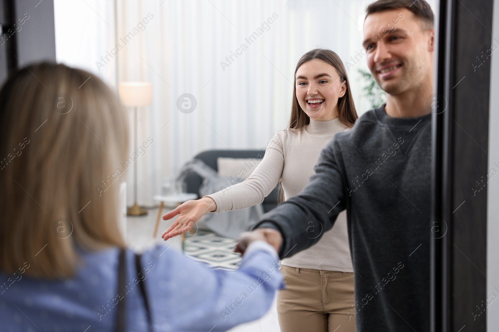 Photo of Lovely couple welcoming friend to their apartment