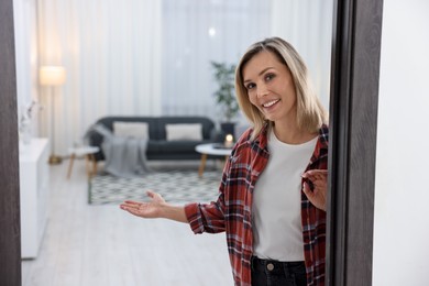 Photo of Happy woman welcoming friend to her house. Space for text