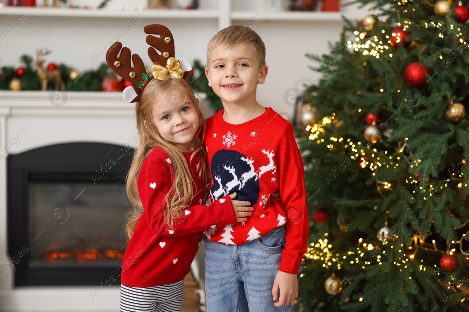 Photo of Adorable little kids near Christmas tree at home