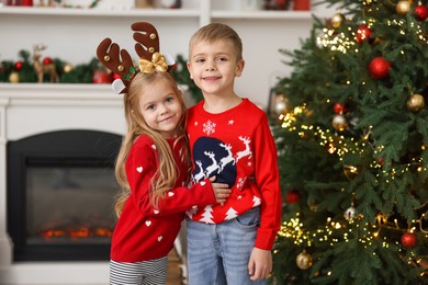 Photo of Adorable little kids near Christmas tree at home