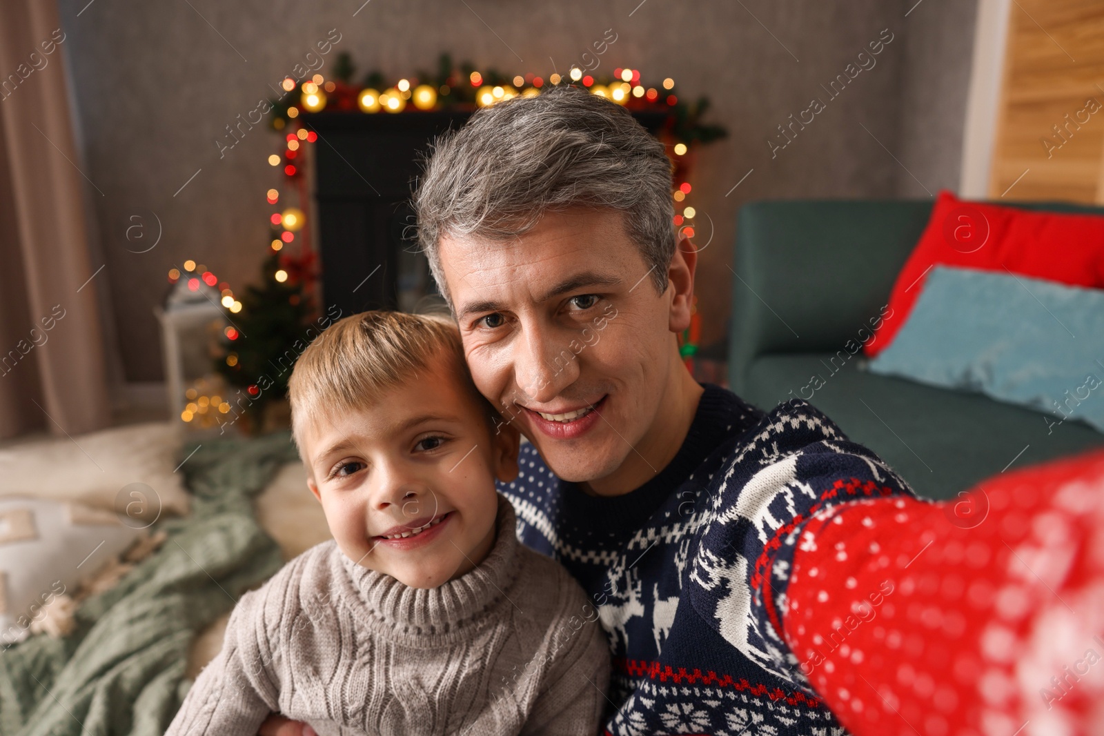 Photo of Dad and son taking selfie together at home. Christmas season