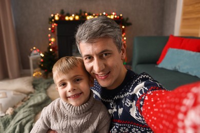 Photo of Dad and son taking selfie together at home. Christmas season