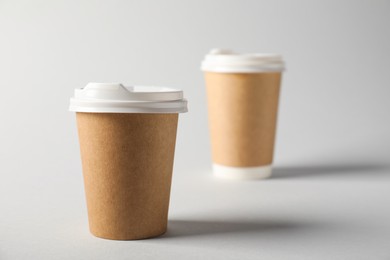 Photo of Paper cups with lids on grey background, selective focus. Mockup for design