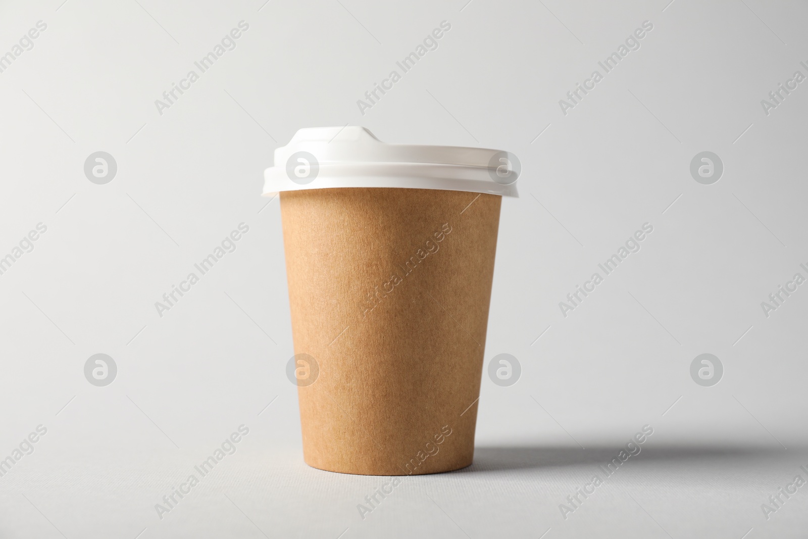 Paper cup with lid on grey background. Mockup for design Photo of Paper cup with lid on grey background. Mockup for design
