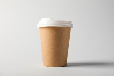 Photo of Paper cup with lid on grey background. Mockup for design