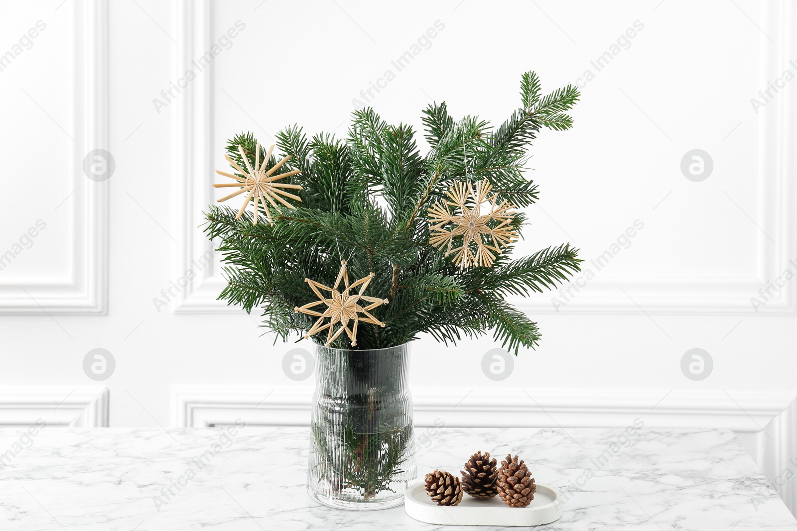 Photo of Beautiful decorated fir tree branches and cones on white table. Christmas season