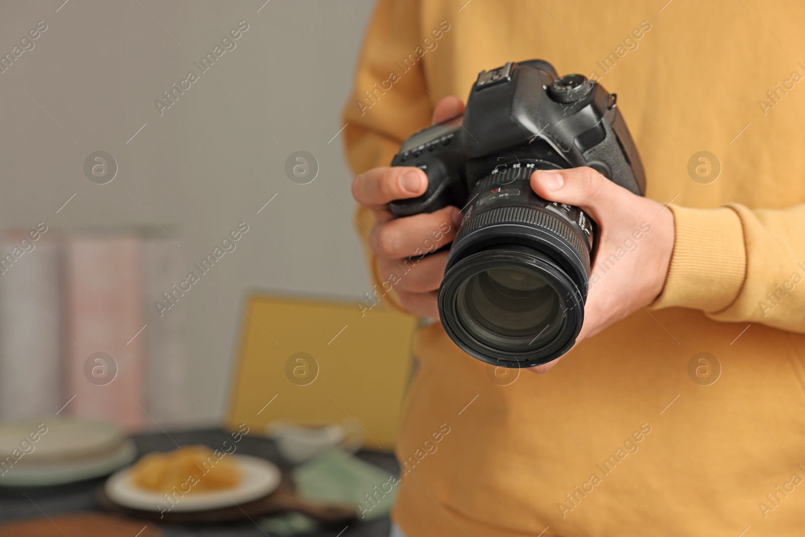 Photo of Photographer with professional camera in studio, closeup. Space for text