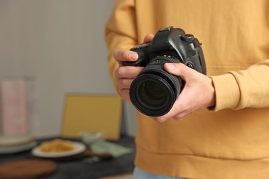 Photo of Photographer with professional camera in studio, closeup. Space for text