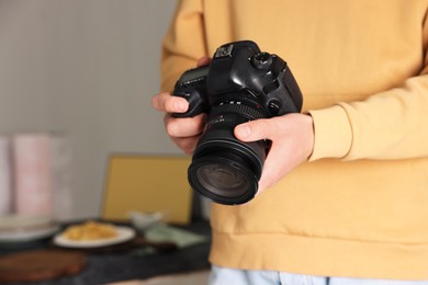 Photo of Photographer with professional camera in studio, closeup. Space for text