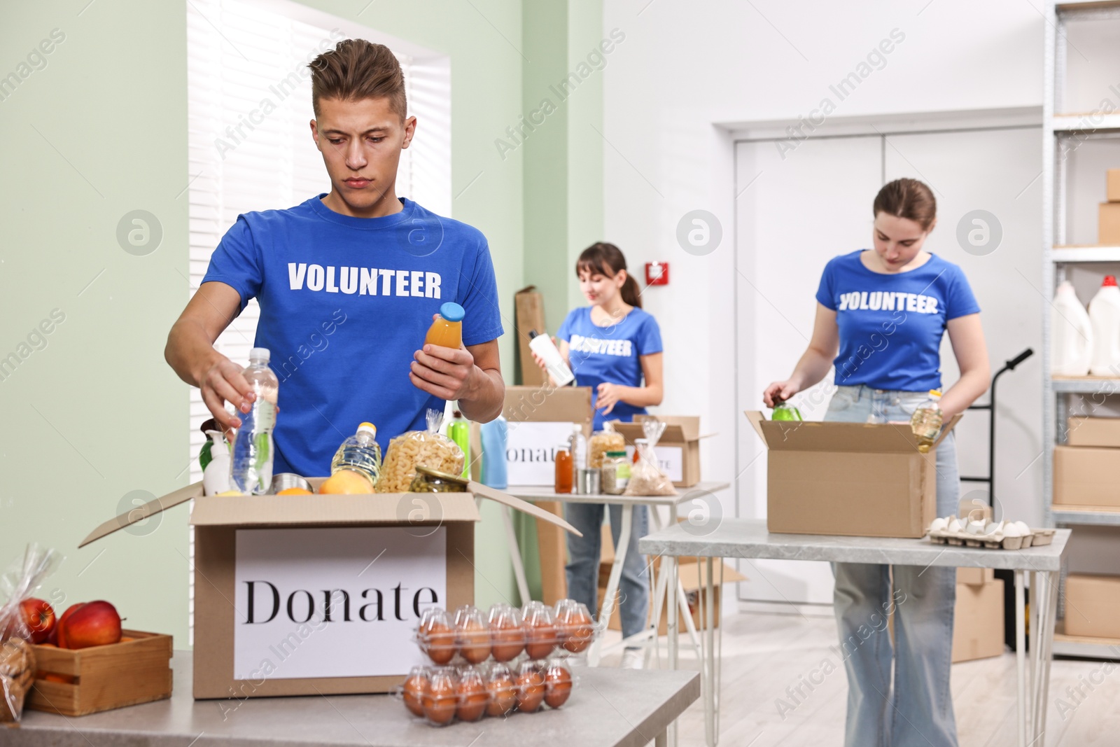 Photo of Volunteers packing food donations at tables indoors