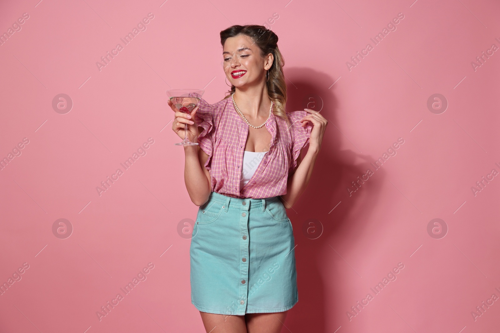 Photo of Happy pin-up woman with cocktail on pink background