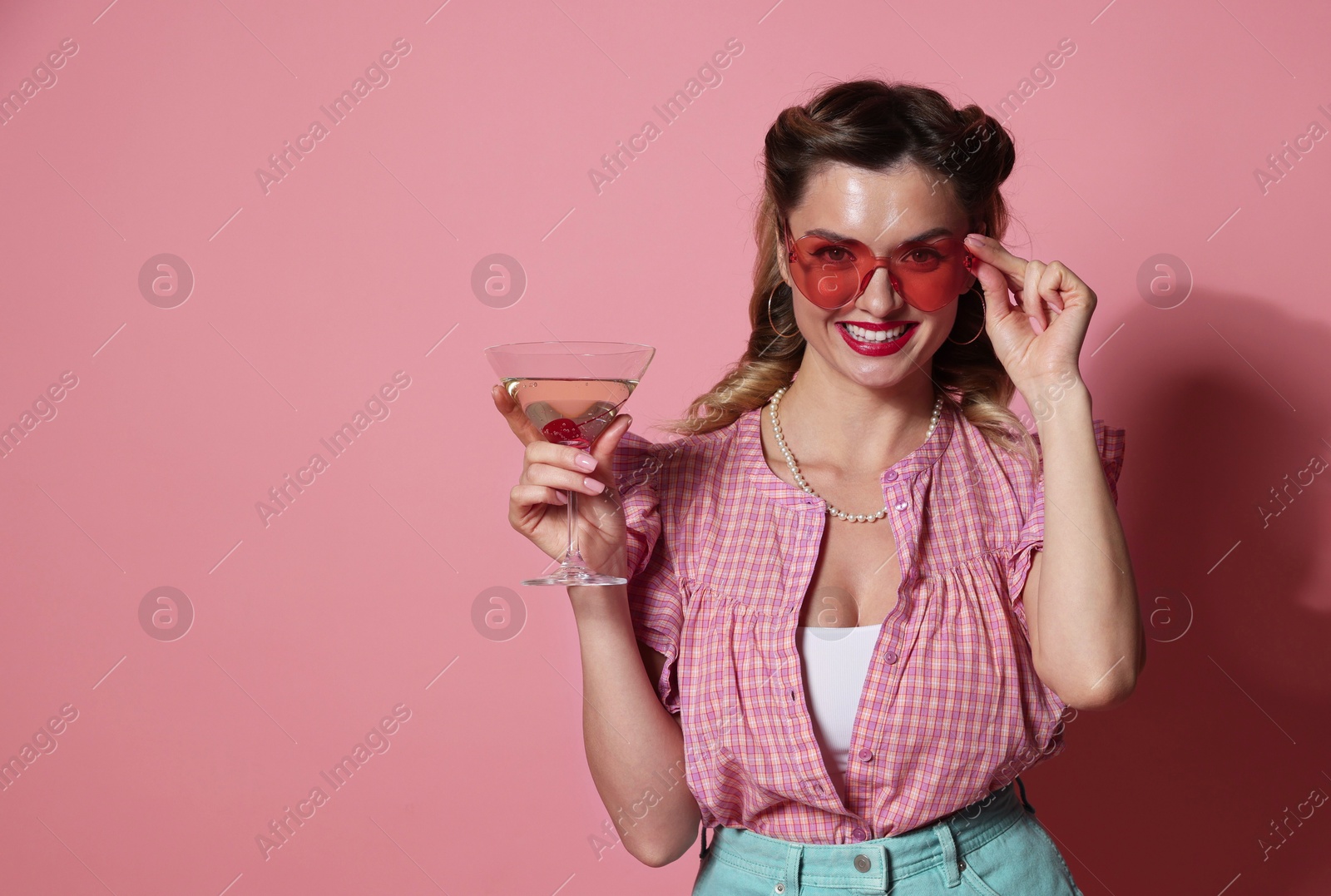 Photo of Happy pin-up woman with cocktail on pink background. Space for text