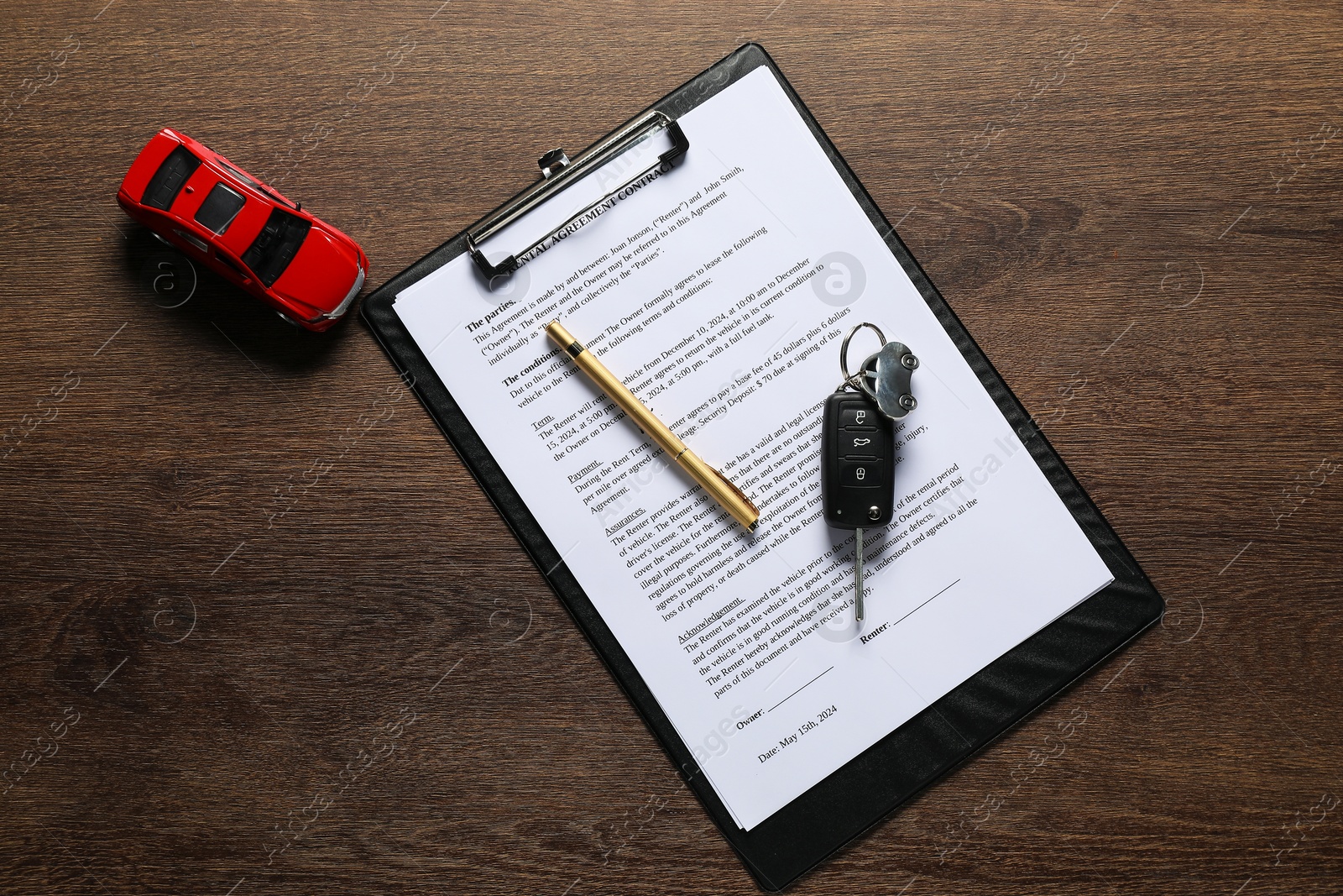 Photo of Car key, model and purchase agreement on wooden table, top view. Buying auto