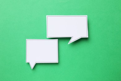 Photo of Blank speech bubbles on green background, top view. Space for text