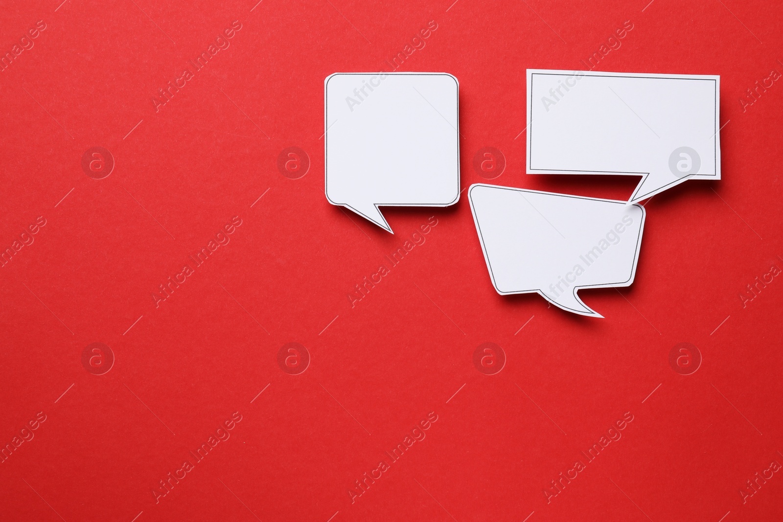 Photo of Blank speech bubbles on red background, top view. Space for text