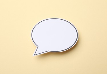 Photo of Blank speech bubble on beige background. Space for text