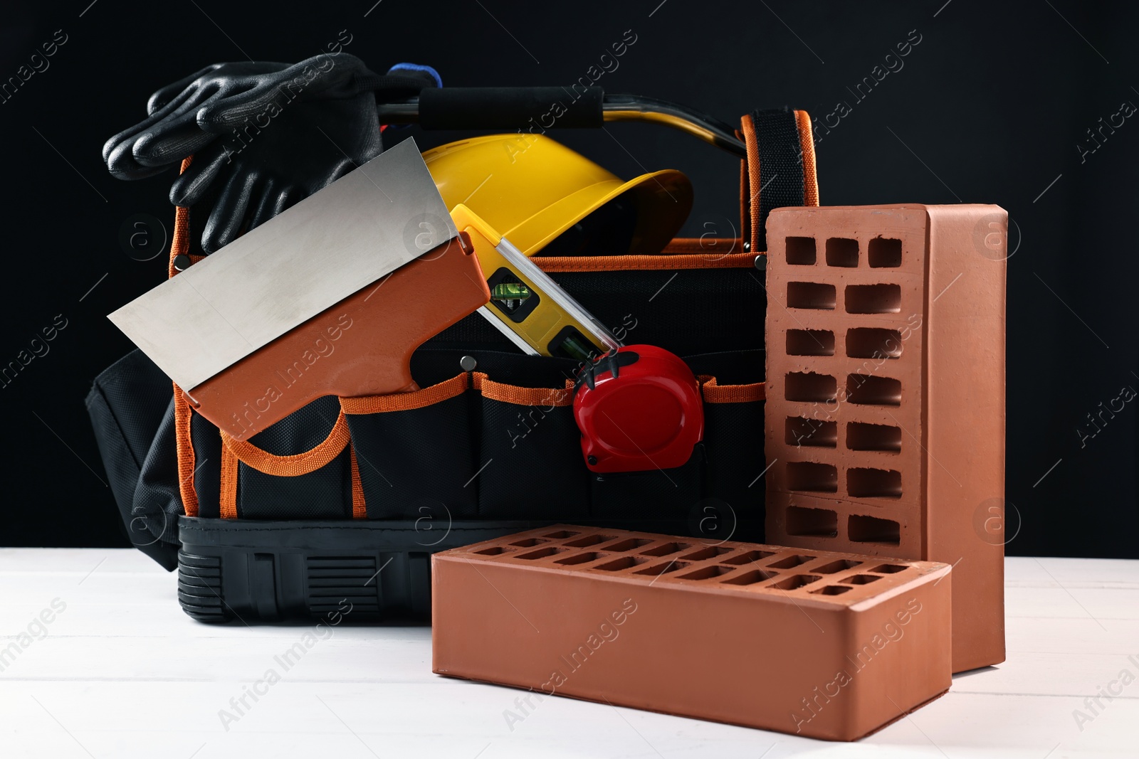 Photo of Different construction material and tools on white wooden table