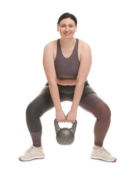 Photo of Plus size woman in gym clothes doing exercise with kettlebell on white background