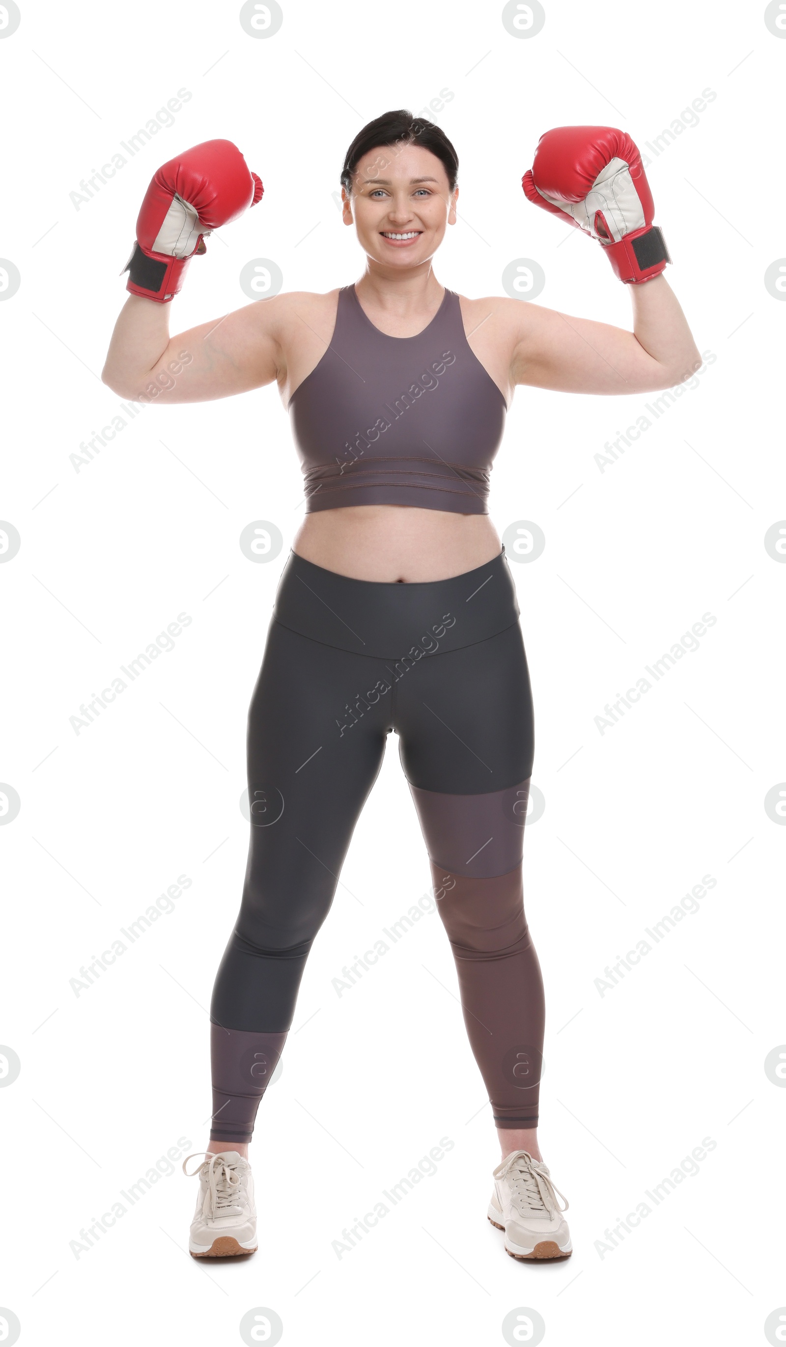 Photo of Plus size woman in gym clothes and boxing gloves on white background