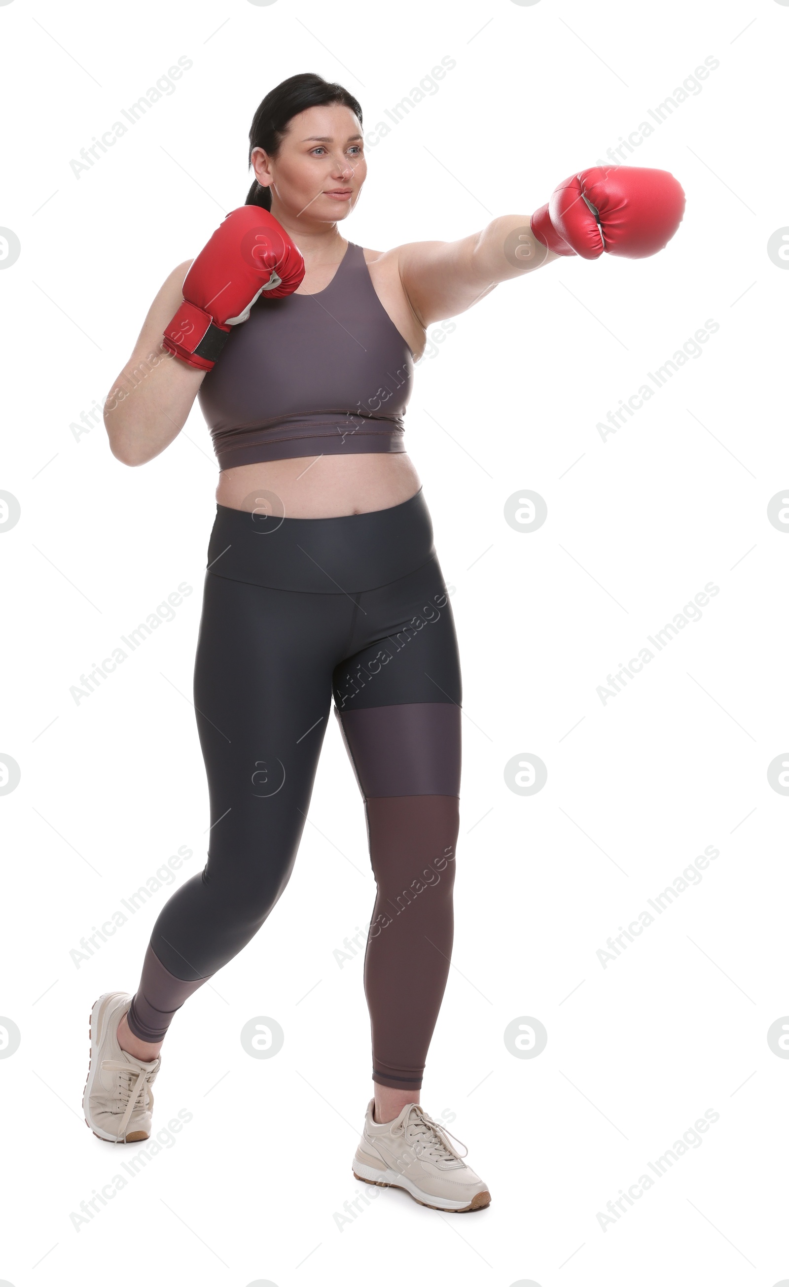 Photo of Plus size woman in gym clothes and boxing gloves on white background