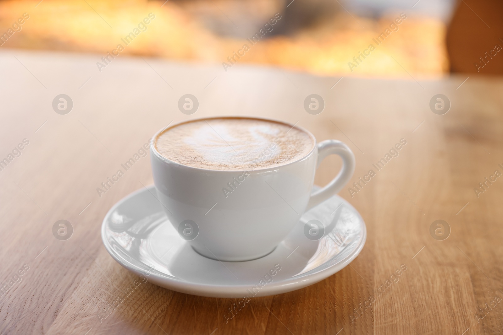 Photo of Cup of aromatic coffee on wooden table in cafe, closeup