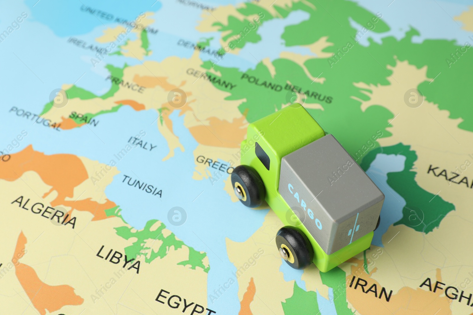 Photo of Toy truck on world map, closeup. Logistics concept