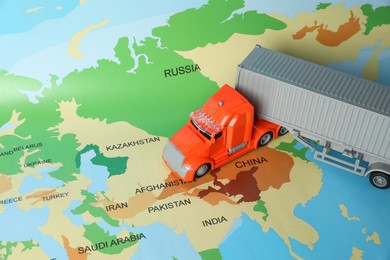 Photo of Toy truck on world map. Logistics concept